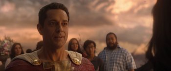Movie still from “Shazam! Fury of the Gods” (2023), directed by David F. Sandberg – A group of people standing next to each other in a field; Close Up shot, Over the shoulder angle