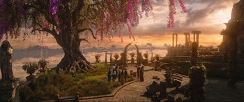 Movie still from “Shazam! Fury of the Gods” (2023), directed by David F. Sandberg – A group of people standing under a large tree; Extreme Wide shot, High angle