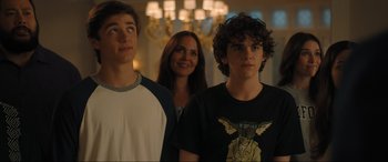 Movie still from “Shazam! Fury of the Gods” (2023), directed by David F. Sandberg – A group of people standing next to each other in a room; Medium shot, Over the shoulder angle