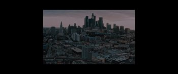Movie still from “Shelter in Place” (2021), directed by Connor Martin – An aerial view of a large city at dusk; Extreme Wide shot, High angle