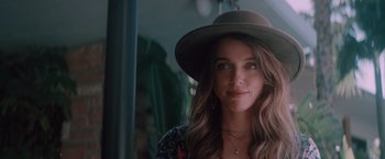 Movie still from “Shelter in Place” (2021), directed by Connor Martin – A woman wearing a brown hat and a floral shirt; Close Up shot, Over the shoulder angle