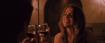 Movie still from “Shelter in Place” (2021), directed by Connor Martin – A woman holding a glass of red wine and smiling; Close Up shot, Over the shoulder angle