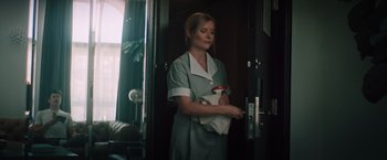 Movie still from “Shelter in Place” (2021), directed by Connor Martin – A woman holding a bottle of liquid in her hands; Medium shot, Low angle