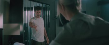 Movie still from “Shelter in Place” (2021), directed by Connor Martin – A man standing in front of a woman in a jail cell; Medium shot, Over the shoulder angle