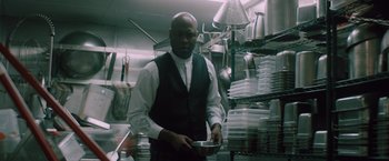 Movie still from “Shelter in Place” (2021), directed by Connor Martin – A man holding a pan in a restaurant kitchen; Medium shot, Low angle