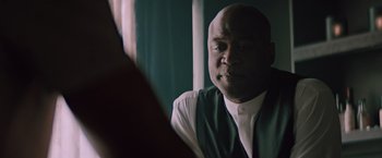 Movie still from “Shelter in Place” (2021), directed by Connor Martin – A man sitting in front of a mirror in front of a window; Close Up shot, Over the shoulder angle