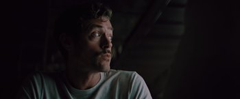 Movie still from “Shelter in Place” (2021), directed by Connor Martin – A person with a beard looking up; Close Up shot, Low angle