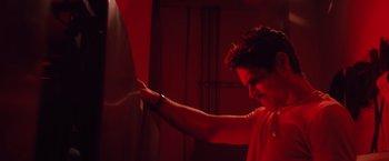Movie still from “Shelter in Place” (2021), directed by Connor Martin – A man in a red shirt pointing to a wall; Medium shot, Low angle