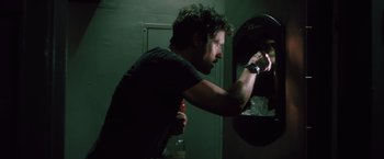 Movie still from “Shelter in Place” (2021), directed by Connor Martin – A man is putting something in a vending machine; Close Up shot, Low angle