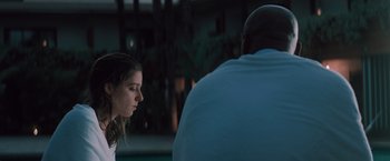 Movie still from “Shelter in Place” (2021), directed by Connor Martin – A woman standing next to a man in a blue shirt; Medium shot, Over the shoulder angle