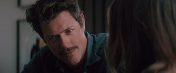 Movie still from “Shelter in Place” (2021), directed by Connor Martin – A person with a mustache looking at a woman; Close Up shot, Over the shoulder angle