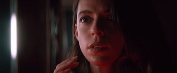Movie still from “Shelter in Place” (2021), directed by Connor Martin – A woman's face in a dark room; Close Up shot, Low angle