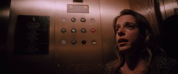 Movie still from “Shelter in Place” (2021), directed by Connor Martin – A woman in an elevator with her mouth wide open; Close Up shot, Low angle