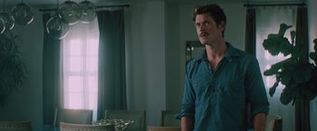Movie still from “Shelter in Place” (2021), directed by Connor Martin – A man standing in front of a dining room table; Close Up shot, Over the shoulder angle