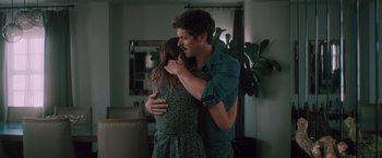 Movie still from “Shelter in Place” (2021), directed by Connor Martin – A man and a woman hugging in a living room; Medium shot, Over the shoulder angle
