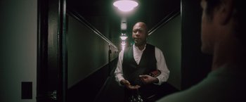 Movie still from “Shelter in Place” (2021), directed by Connor Martin – A man holding a bottle of wine in his hands; Medium shot, Low angle