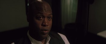 Movie still from “Shelter in Place” (2021), directed by Connor Martin – A person wearing a shirt and vest; Close Up shot, Over the shoulder angle