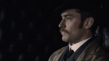 Movie still from “Sherlock Holmes” (2009), directed by Guy Ritchie – A person wearing a hat and a suit; Close Up shot, Low angle