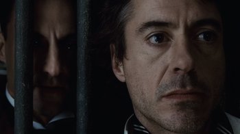 Movie still from “Sherlock Holmes” (2009), directed by Guy Ritchie – A man's face in front of another man's reflection; Close Up shot, Over the shoulder angle