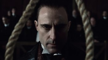 Movie still from “Sherlock Holmes” (2009), directed by Guy Ritchie – A person wearing a suit and tie; Close Up shot, Low angle