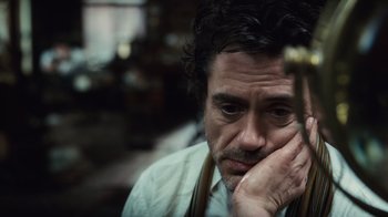 Movie still from “Sherlock Holmes” (2009), directed by Guy Ritchie – A person with his hand on his face; Close Up shot, High angle