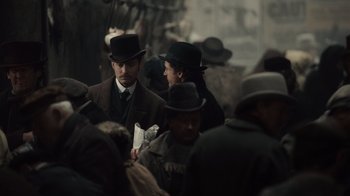 Movie still from “Sherlock Holmes” (2009), directed by Guy Ritchie – A group of people wearing hats and coats; Medium shot, Over the shoulder angle