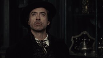 Movie still from “Sherlock Holmes” (2009), directed by Guy Ritchie – A person wearing a suit and hat; Close Up shot, Low angle