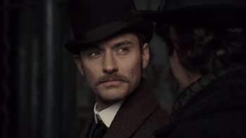 Movie still from “Sherlock Holmes” (2009), directed by Guy Ritchie – A person wearing a top hat; Close Up shot, Over the shoulder angle