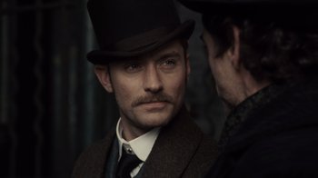 Movie still from “Sherlock Holmes” (2009), directed by Guy Ritchie – A man in a top hat and a tie; Close Up shot, Over the shoulder angle