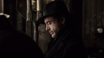 Movie still from “Sherlock Holmes” (2009), directed by Guy Ritchie – A man wearing a black hat and a black jacket; Close Up shot, Low angle