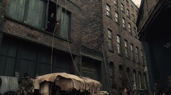 Movie still from “Sherlock Holmes” (2009), directed by Guy Ritchie – A man standing on a window ledge looking out of a window; Extreme Wide shot, Low angle