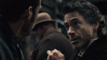 Movie still from “Sherlock Holmes” (2009), directed by Guy Ritchie – A man with a beard is talking to another man; Close Up shot, Over the shoulder angle