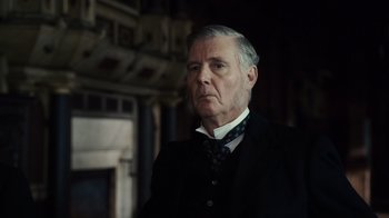 Movie still from “Sherlock Holmes” (2009), directed by Guy Ritchie – An older man wearing a suit and tie; Close Up shot, Over the shoulder angle