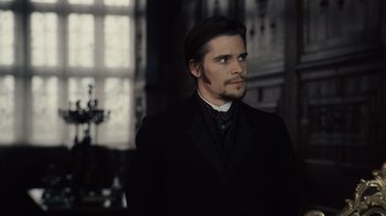 Movie still from “Sherlock Holmes” (2009), directed by Guy Ritchie – A man in a black suit and white shirt; Medium shot, Over the shoulder angle