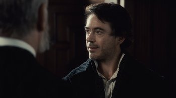 Movie still from “Sherlock Holmes” (2009), directed by Guy Ritchie – A person wearing a sweater; Close Up shot, Over the shoulder angle