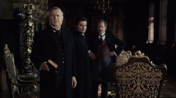Movie still from “Sherlock Holmes” (2009), directed by Guy Ritchie – A group of men standing next to each other in a room; Medium shot, Low angle