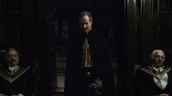 Movie still from “Sherlock Holmes” (2009), directed by Guy Ritchie – A man wearing a black cape and a black and gold tie; Medium shot, Low angle