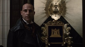 Movie still from “Sherlock Holmes” (2009), directed by Guy Ritchie – A man standing in front of an ornate gold mirror; Medium shot, Low angle