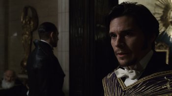 Movie still from “Sherlock Holmes” (2009), directed by Guy Ritchie – A man standing next to another man wearing a suit; Close Up shot, Over the shoulder angle