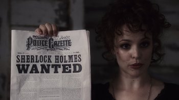 Movie still from “Sherlock Holmes” (2009), directed by Guy Ritchie – A woman holding up an old newspaper; Close Up shot, Over the shoulder angle