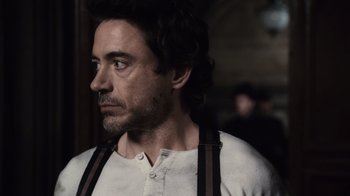 Movie still from “Sherlock Holmes” (2009), directed by Guy Ritchie – A person wearing a shirt and suspenders; Close Up shot, Over the shoulder angle