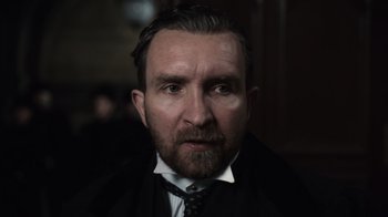 Movie still from “Sherlock Holmes” (2009), directed by Guy Ritchie – A person wearing a suit and tie; Close Up shot, Low angle