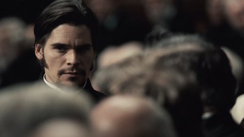Movie still from “Sherlock Holmes” (2009), directed by Guy Ritchie – A person looking at a crowd of people; Close Up shot, Over the shoulder angle