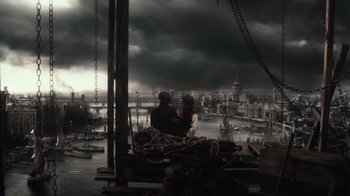 Movie still from “Sherlock Holmes” (2009), directed by Guy Ritchie – Two people sitting on a dock looking out at a city; Extreme Wide shot, High angle