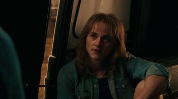 Movie still from “Bohemian Rhapsody” (2018), directed by Bryan Singer – A woman sitting on a bus looking at the camera; Close Up shot, Over the shoulder angle