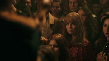 Movie still from “Bohemian Rhapsody” (2018), directed by Bryan Singer – A crowd of people standing in a room; Medium shot, Over the shoulder angle