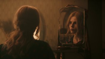 Movie still from “Bohemian Rhapsody” (2018), directed by Bryan Singer – A woman looking at her reflection in a mirror; Close Up shot, Over the shoulder angle