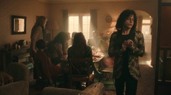 Movie still from “Bohemian Rhapsody” (2018), directed by Bryan Singer – A group of people sitting around a dining room table; Wide shot, Over the shoulder angle