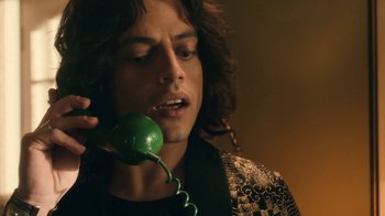 Movie still from “Bohemian Rhapsody” (2018), directed by Bryan Singer – A man holding a phone up to his ear; Close Up shot, Low angle