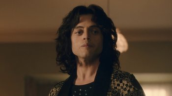 Movie still from “Bohemian Rhapsody” (2018), directed by Bryan Singer – A man with long hair is looking at the camera; Close Up shot, Low angle
